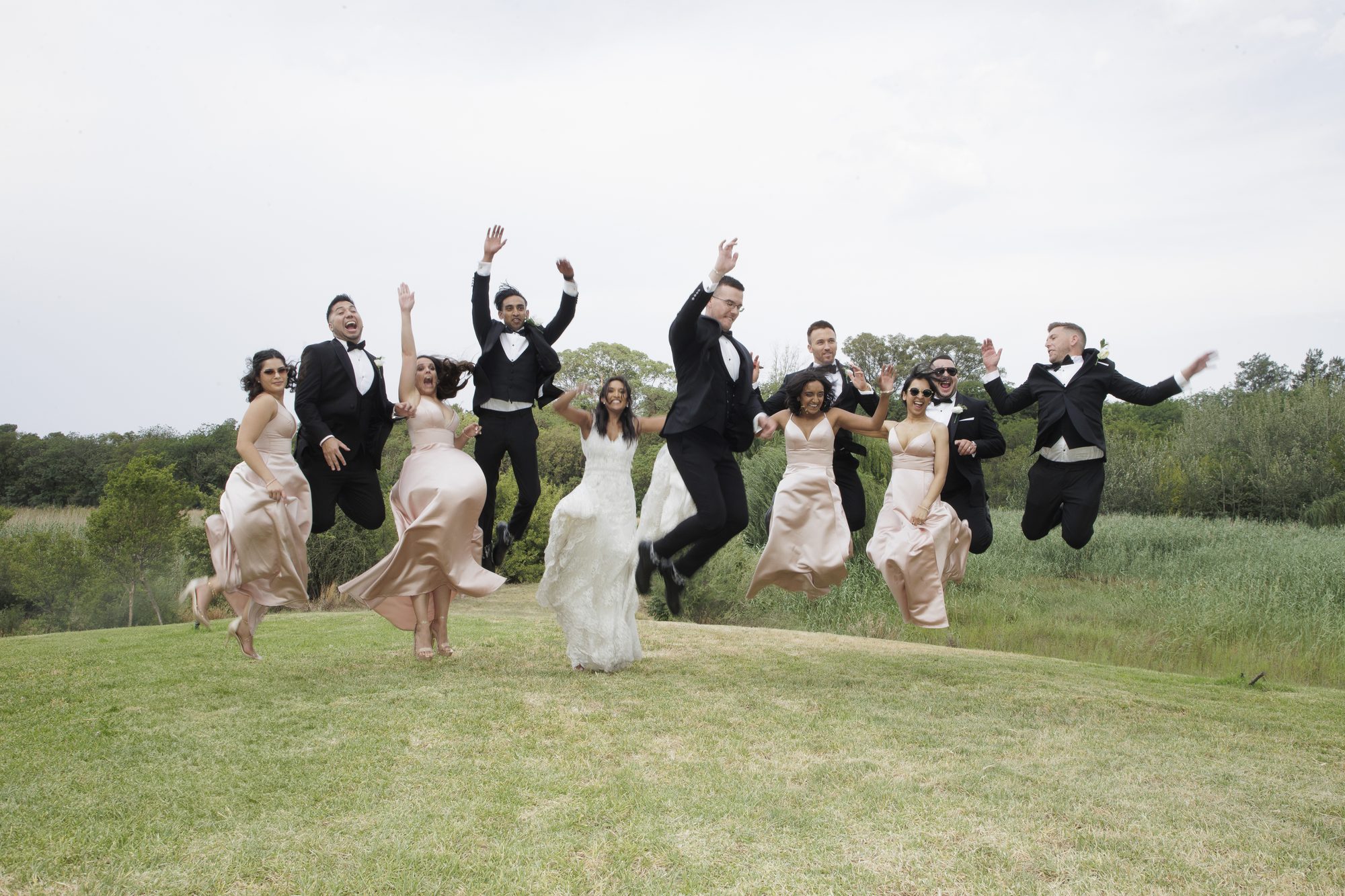 Wedding party jumping in celebration